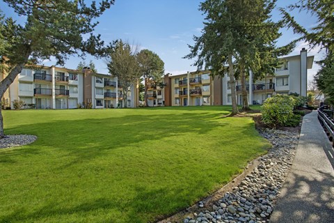A grassy area in front of apartment buildings.