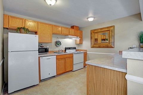 A kitchen with a white refrigerator and wooden cabinets.