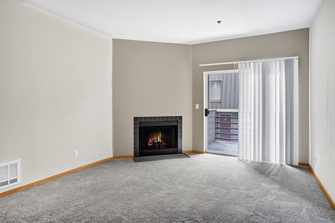 A living room with a fireplace and a carpeted floor.