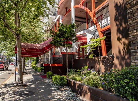 A red building with a red awning and a red car parked in front.