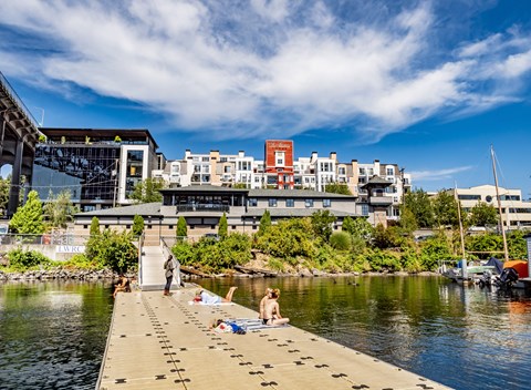 A person is sitting on a dock by the water.