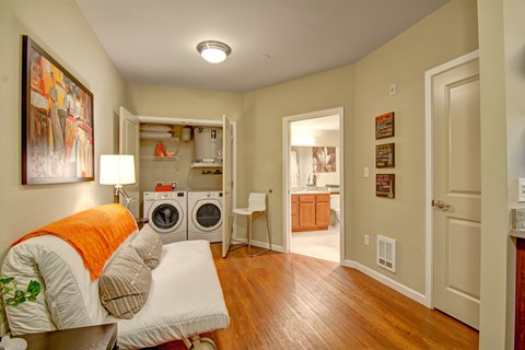 A bedroom with a washer and dryer in the closet.