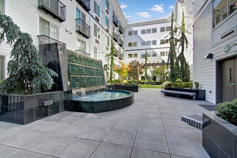 A courtyard with a pool surrounded by buildings.