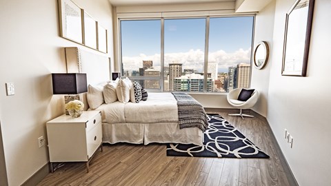 A bedroom with a large bed and a view of the city.
