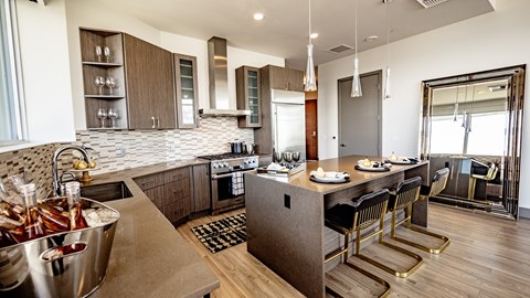 A modern kitchen with a bar area and a dining table set for two.