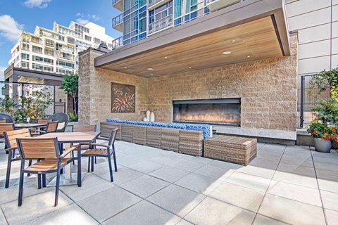 A patio with a fireplace and chairs.