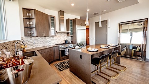 A modern kitchen with a bar area and a dining table set for two.
