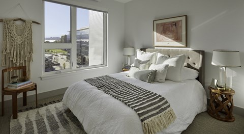 A bedroom with a large bed and a view of the outside.