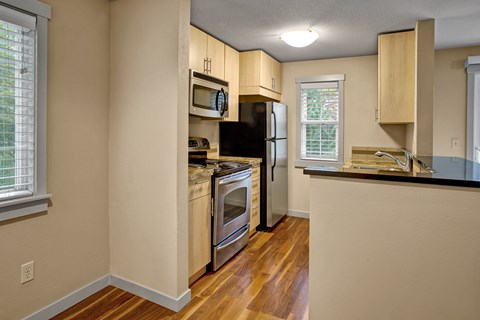 A kitchen with wooden cabinets and a black countertop.