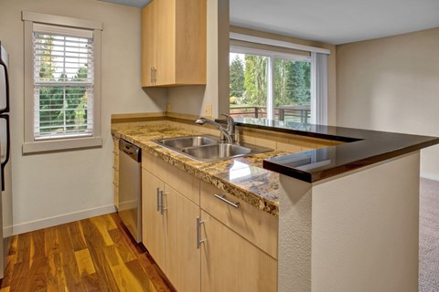 A kitchen with wooden cabinets and a granite countertop.