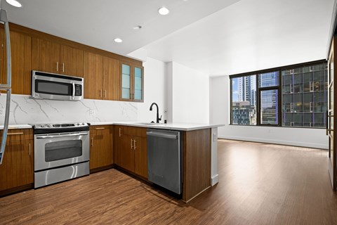 A kitchen with wooden cabinets and a marble countertop.