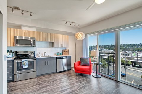 A modern kitchen with a red chair and a view of the city.