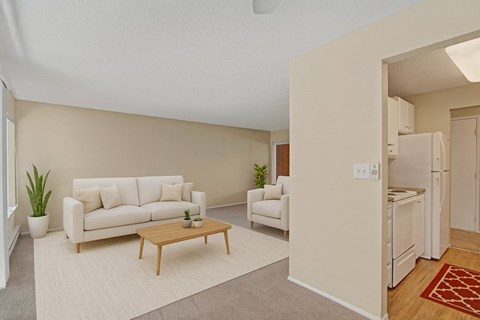 A living room with a white couch and a wooden coffee table.