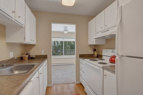 A kitchen with white cabinets and appliances.