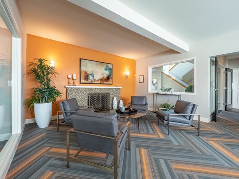 A living room with grey chairs and a fireplace.