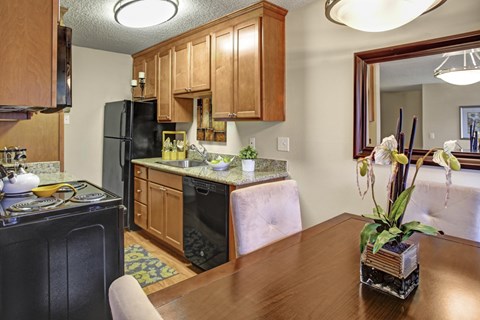 A kitchen with wooden cabinets and black appliances.