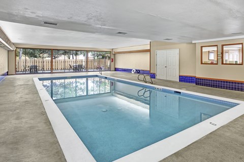 A large indoor swimming pool with a glass divider.