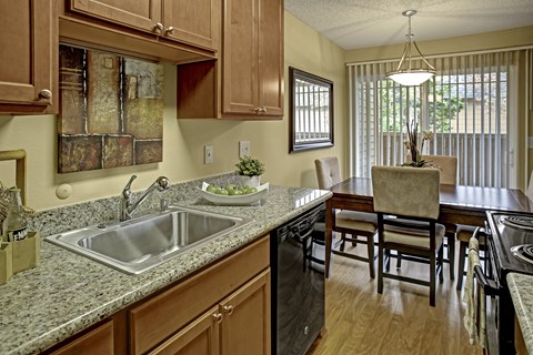 A kitchen with wooden cabinets and granite countertops.