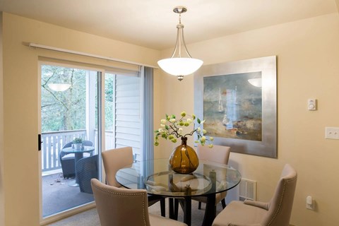 A dining room with a glass table and chairs.
