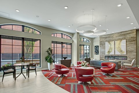 A living room with a red rug and red chairs.