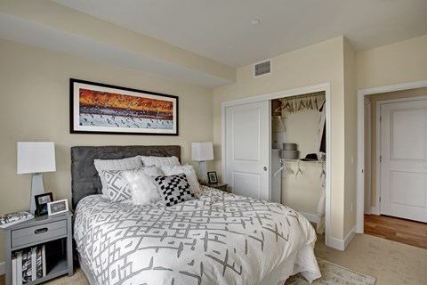 A bedroom with a large bed and a painting on the wall.