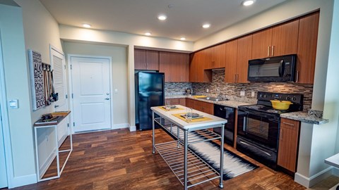 A kitchen with wooden cabinets and a black oven.