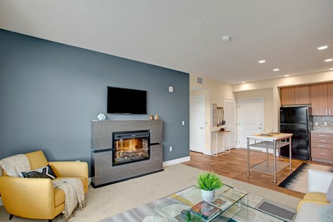 A modern living room with a yellow chair and a fireplace.