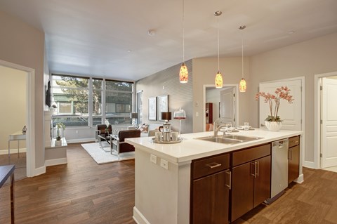 A kitchen with a white counter top and wooden cabinets.