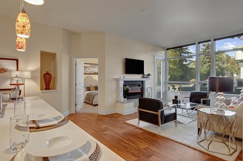 A modern living room with a dining table set for two.