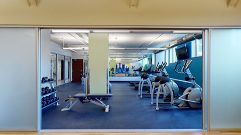 A modern fitness center here at Avenir featuring cardio machines, free weights, and open workout space. The bright windows and clean layout create an energizing, spacious, and motivating environment.