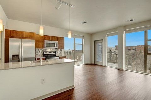 A kitchen with a white counter top and wooden floors.