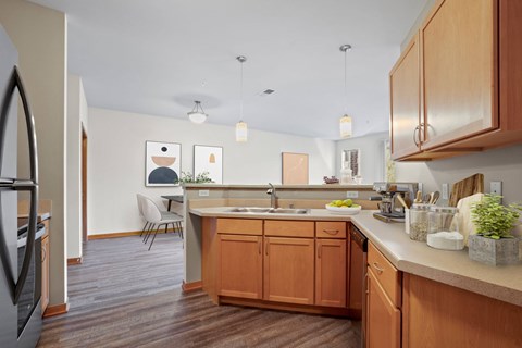A kitchen with wooden cabinets and a white counter.