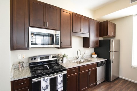 A kitchen with dark brown cabinets and stainless steel appliances.