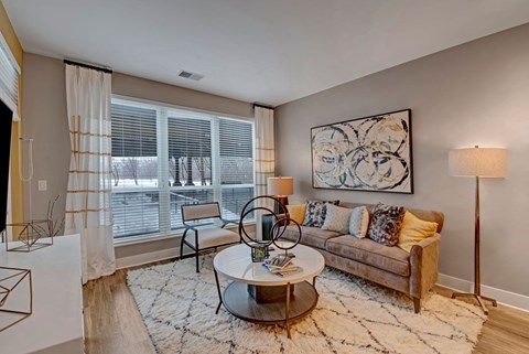 A living room with a couch, a coffee table, and a painting on the wall.