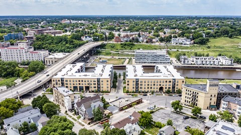 A modern exterior building view of River House with large windows, a neutral-toned exterior, and a welcoming entrance. The property creates a stylish multi-story design and create an attractive, upscale atmosphere.