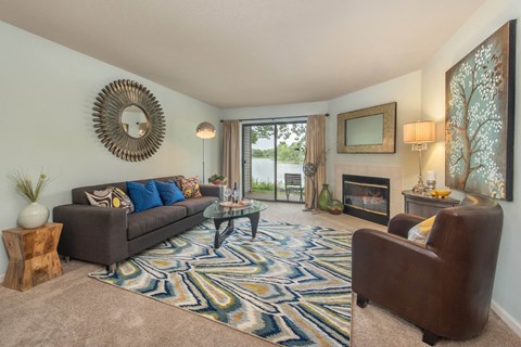 A living room with a grey couch and a patterned rug.