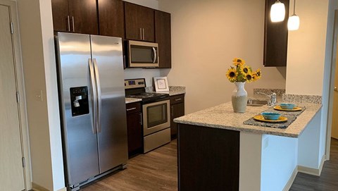 A kitchen with a stainless steel refrigerator and microwave.