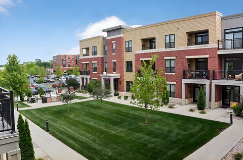 A large grassy area in front of apartment buildings.