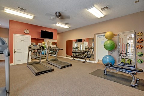 A modern fitness center here at St. James Place with treadmills, free weights, and strength training equipment. A spacious layout and full wall mirrors create a bright and motivating workout environment.