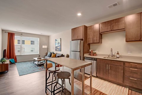 A kitchen with wooden cabinets and a table with two chairs.