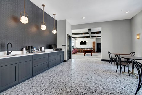 A kitchen with a patterned floor and a dining area with a table and chairs.