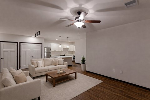 A living room with a white ceiling fan and a white rug.