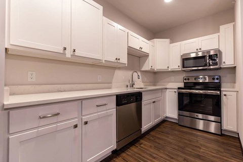 A kitchen with white cabinets and stainless steel appliances.