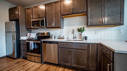 A kitchen with wooden cabinets and a white tile backsplash.
