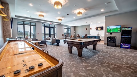 A spacious resident lounge here at Van Buren East with a pool table and shuffleboard. A community kitchen, arcade games, and comfortable seating create a fun, social, and inviting atmosphere.