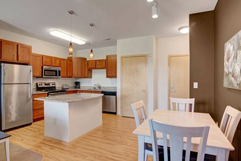 A kitchen with wooden cabinets and a white island.