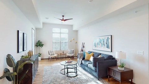 A living room with a grey couch, a coffee table, and a painting on the wall.