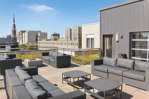 A patio with black furniture and a building in the background.