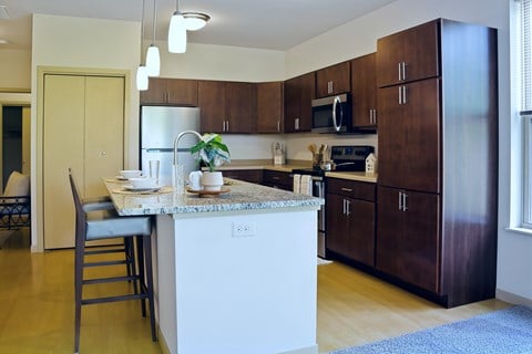 A kitchen with brown cabinets and a white island.