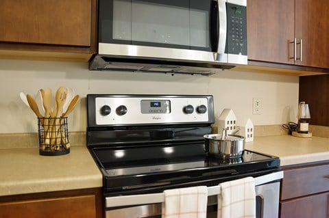 A modern kitchen with a black stove top oven and a microwave above it.